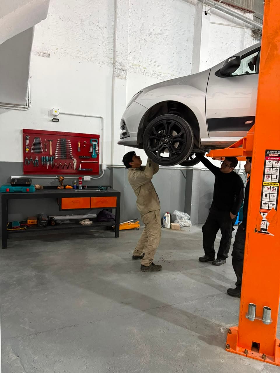 Equipo de Magari Service desmontando la rueda de un vehículo en el elevador